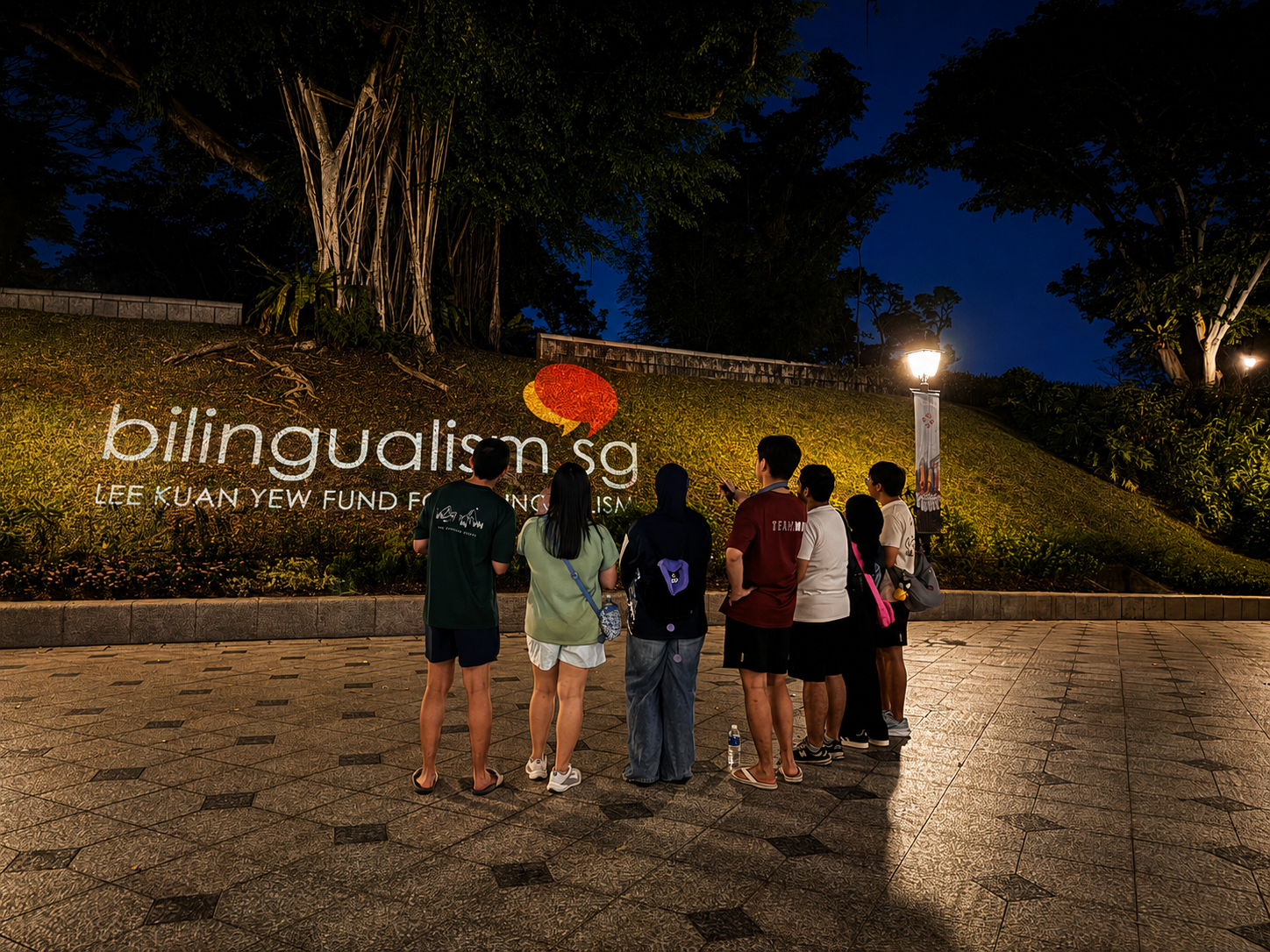 Group of participants looking at LKYFB's logo being projected on the law of Fort Canning Hill.
